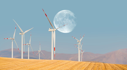 Wind turbines generating electricity with full moon 