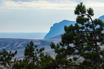 Fototapeta na wymiar Beautiful seascape with rocky coast onhorizon. Panoramic view of mountains along Black Sea coast of Crimea from height of mountain range between Feodosia and Koktebel.