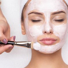 Woman receiving facial mask at beauty salon - obrazy, fototapety, plakaty