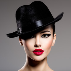 Сlose-up portrait of a woman in a black hat  with red lips