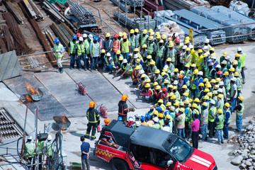 Construction workers wearing helmets at a construction site learning fire fighting skills