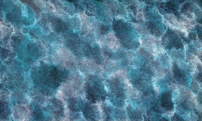 Abstract painted texture. Blue wavy surface with sun glare. Ripples on the water