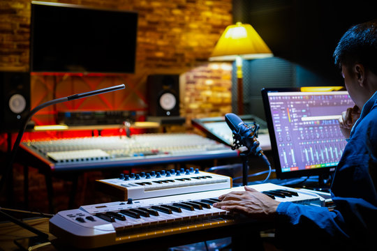 professional male music producer arranging a song on computer in recording studio. music production concept