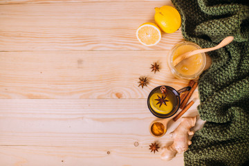 Cup warm water with lemon, honey, ginger root, cinnamon and anise. Ingredients on a wooden background. Concept of alternative medicine.