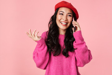 Image of attractive beautiful asian girl smiling and talking on smartphone