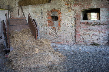 Abandoned farmhouse with hay bales on the cart