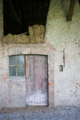 Entrance to abandoned building with brick walls and wooden door