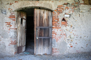 Fototapeta na wymiar Entrance to abandoned building with brick walls and wooden door