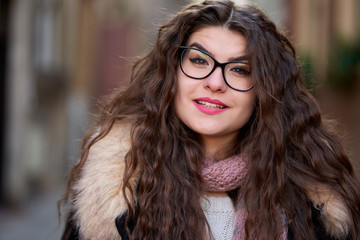 Curly haired young woman outdoor, closeup