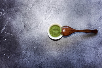 Green tea matcha in a bowl with a wooden spoon