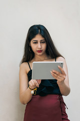 Fototapeta premium One Indian female girl holding and swiping touch screen mobile device with her right index finger
