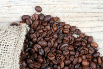 coffee beans with burlap sack on wooden background