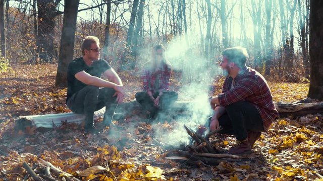 Tourists sitting by campfire with thick smoke
