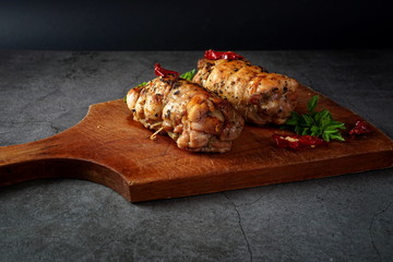 Chicken roll on a cutting Board, on a dark background. Healthy diet