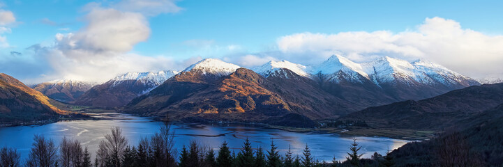 The Five Sisters of Kintail with snow on their tops towering above Loch Duich and the villages of...