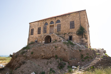 Fototapeta na wymiar View of a traditional Lebanese house among the Roman ruins of Byblos. Byblos, Lebanon - June, 2019