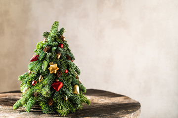 Christmas tree on a brown, wooden background.