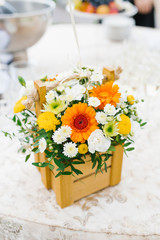 Obraz na płótnie Canvas Composition bouquet of flowers white, yellow and orange: chrysanthemums, gerberas in a wooden box. A gift for a birthday, wedding or celebration