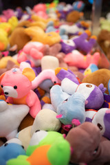 Fototapeta na wymiar Pile of brightly colored stuffed toy animals in an arcade game 