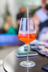 Cocktail in glass with tube on restaurant table