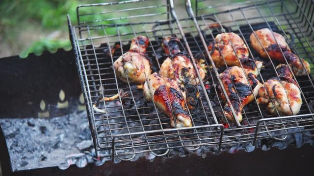 crispy chicken legs in a grill grilled on charcoal in the evening