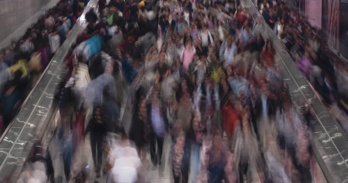 Crowds of commuters rush through a busy subway station in a high-speed timelapse.