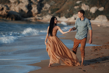 Couple in love at dawn by the sea. Honeymoon trip. Man and woman traveling. Happy couple by the sea...