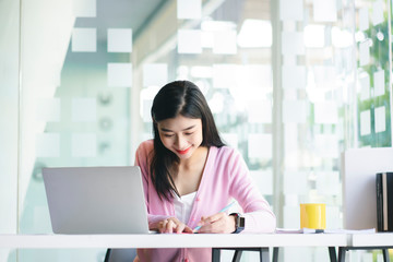Obraz na płótnie Canvas Confident happiness young woman working on laptop or notebook in her office. Beautiful Freelancer Woman working online at her home. Beauty Asian business woman concept.