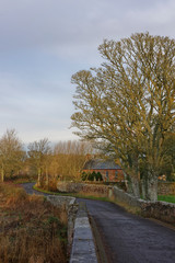 The small Rectangular shaped Lunan Parish Church, viewed from the narrow road bridge spanning Lunan water on the edge of the Village.
