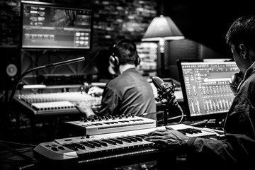 professional male producer, director, editor, composer working with sound engineer in recording studio. music production concept - 310630315