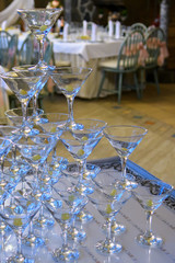 A pile of champagne glasses at a party. Alcoholic luxury pyramid of wineglass.