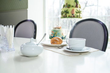 Fruit tea and delicious fresh croissant on the table in a cozy coffee shop
