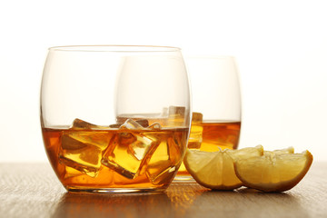 Two glasses with whiskey with ice cubes