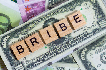 Fototapeta na wymiar words bribe, graft, corruption on the money banknotes background