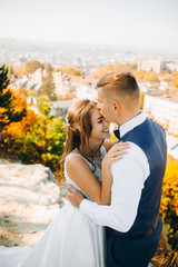 Portrait of a beautiful couple against the background of autumn trees and the city