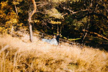 The couple standing on the stairs the background of pine forest. Top view