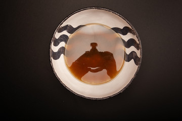 dark broth in a white plate