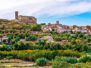 Fototapeta na wymiar Ancient stone hilltop village in Catalonia (Spain). Traditional Catalan autumn rural landscape with medieval houses, castle and chapels among olive fields