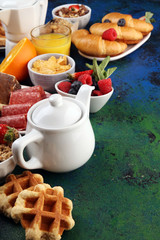 Breakfast served with coffee, orange juice, croissants, cereals and fruits. Balanced diet. Continental breakfast with granola and fruits