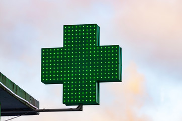 Green medical cross sign in winter day