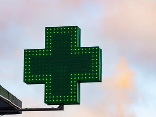 Green medical cross sign in winter day