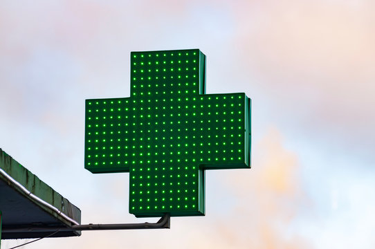 Green Medical Cross Sign In Winter Day