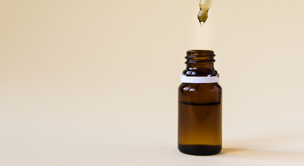 close-up, cosmetics, glass bottle with a pipette and hyaluronic acid on a yellow background