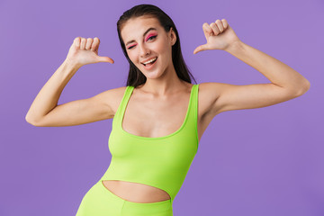 Photo of young funny woman pointing thumbs at herself and winking