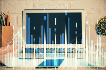 Stock market graph on background with desk and personal computer. Double exposure. Concept of financial analysis.