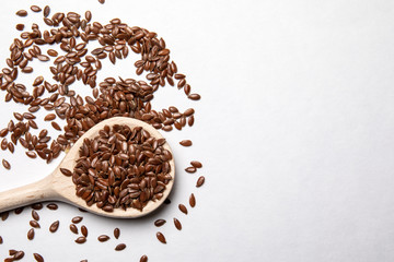 Linseeds and a spoon on a white background