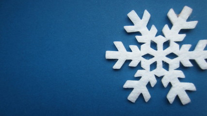 Decorative snow star with white felt blue background. Creative Christmas concept. Flat lay.