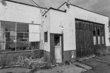 Black and white photo of abandoned vintage service and gas station