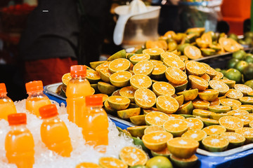 Fresh orange juice in bottle with Orange slices put on the table at local market.