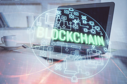 Multi exposure of blockchain theme hologram and table with computer background. Concept of bitcoin crypto currency.